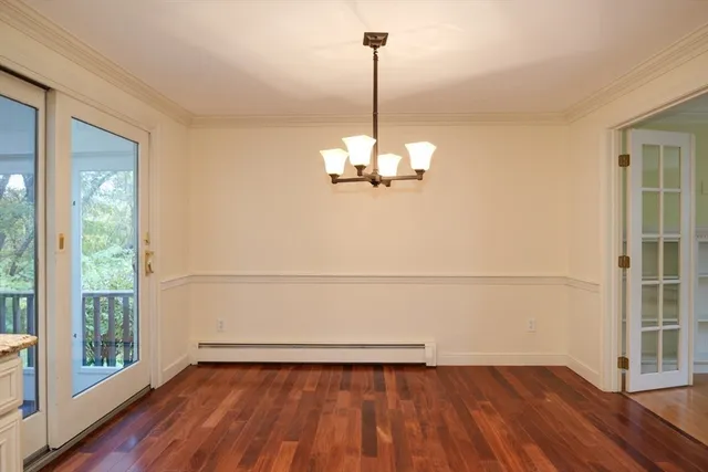 a view of a room with wooden floor fridge and a window