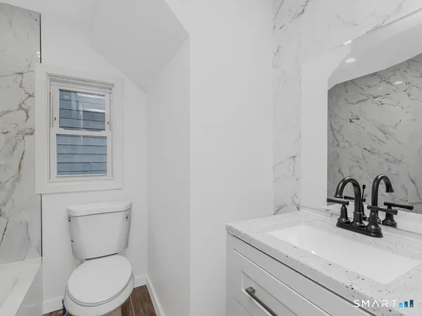a kitchen with stainless steel appliances granite countertop a stove a sink and white cabinets