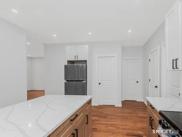 a kitchen with a refrigerator a stove and white cabinets