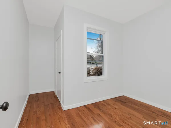 a view of a room with wooden floor and window