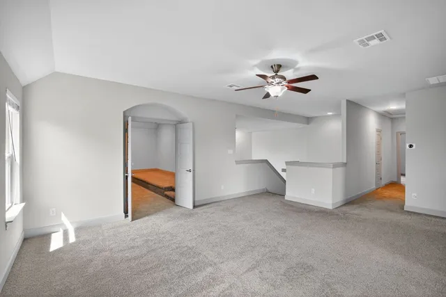 wooden floor in an empty room with a ceiling fan