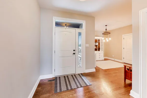 a view of a room with wooden floor and a bathroom