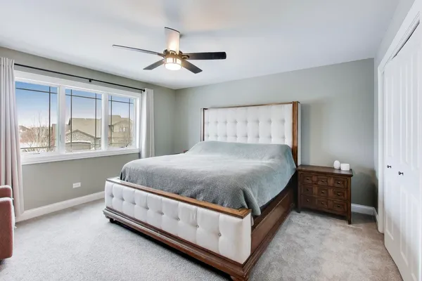 a large bed sitting in a bedroom next to a window