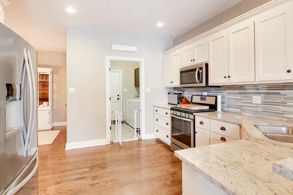 a kitchen with stainless steel appliances granite countertop a refrigerator stove top oven and sink