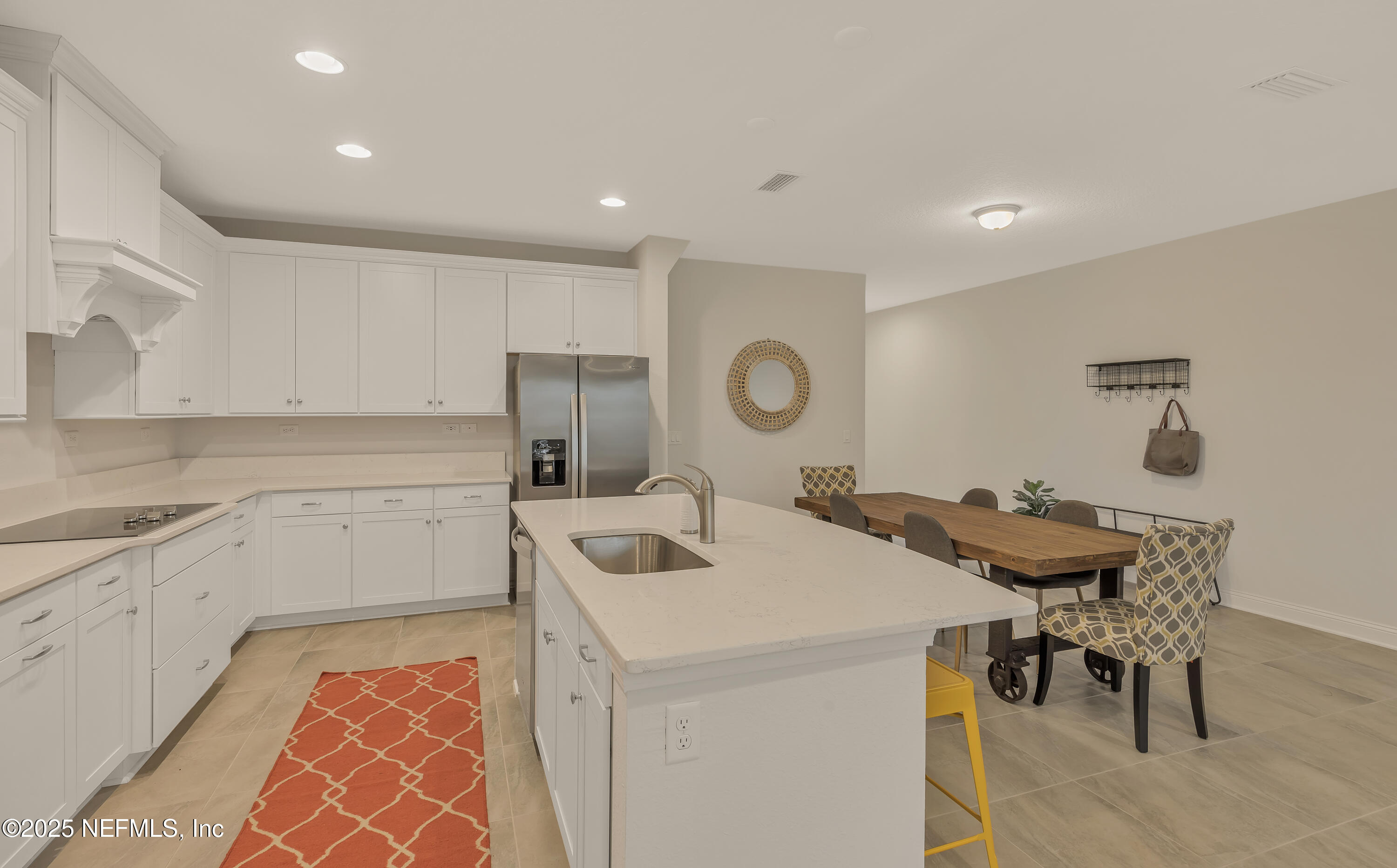 381 Woods Lane St. Augustine, FL 32092 - Photo 9 of 16 a kitchen with a sink a stove a refrigerator and white cabinets with wooden floor