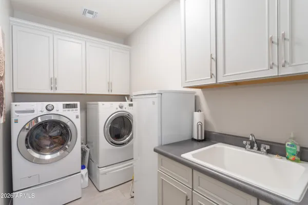 a utility room with sink dryer and washer