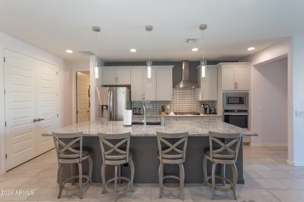 a kitchen with kitchen island granite countertop wooden cabinets and stainless steel appliances