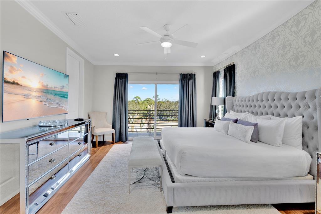 7580 Excitement Drive Reunion, FL 34747 - Photo 17 of 47 a bedroom with a large bed and a flat tv screen on dresser