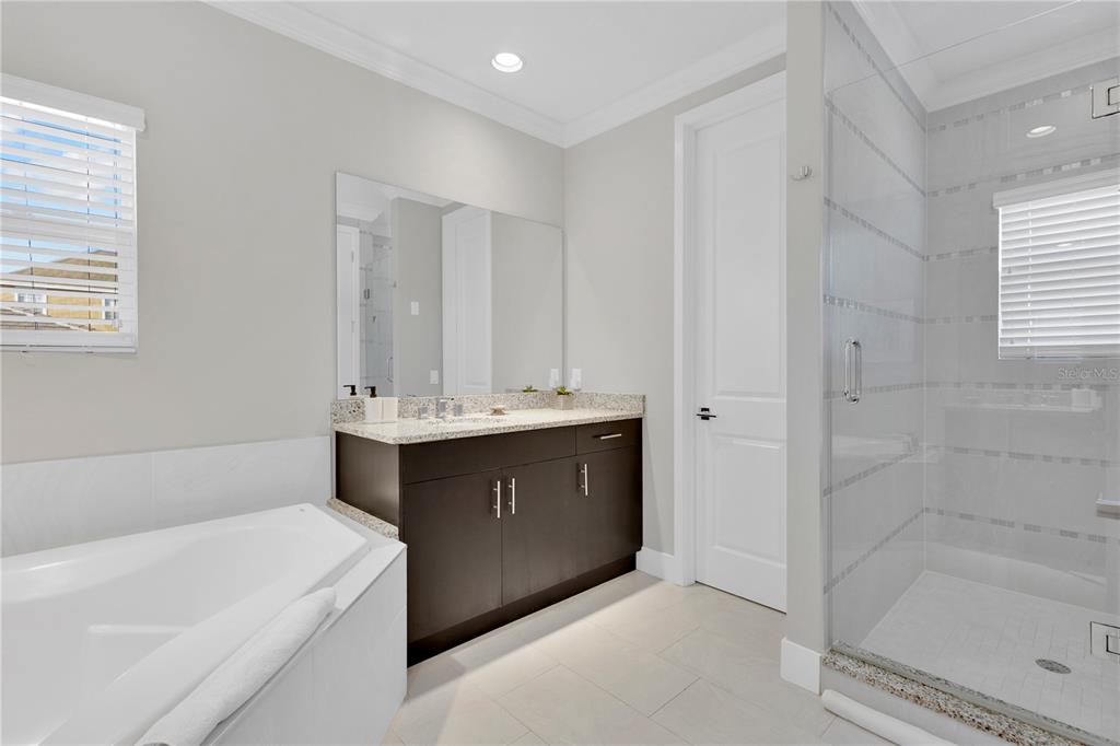 7580 Excitement Drive Reunion, FL 34747 - Photo 18 of 47 a bathroom with a bathtub sink vanity and mirror