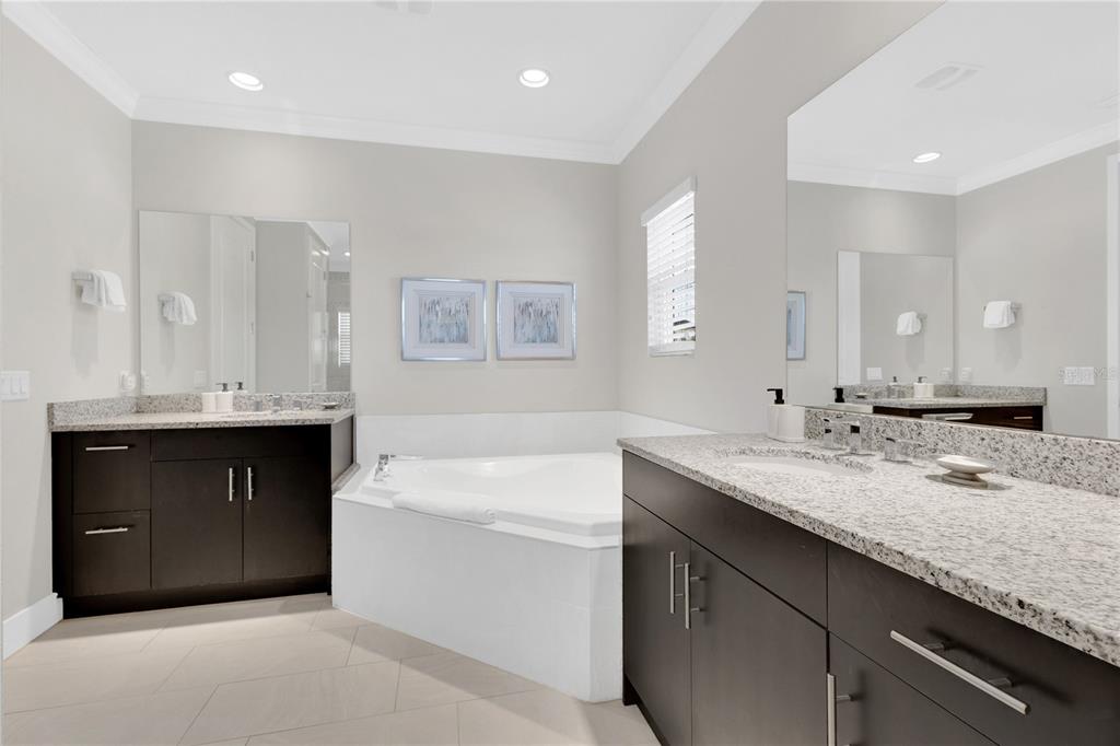 7580 Excitement Drive Reunion, FL 34747 - Photo 19 of 47 a bathroom with a sink double vanity granite tub shower and a mirror