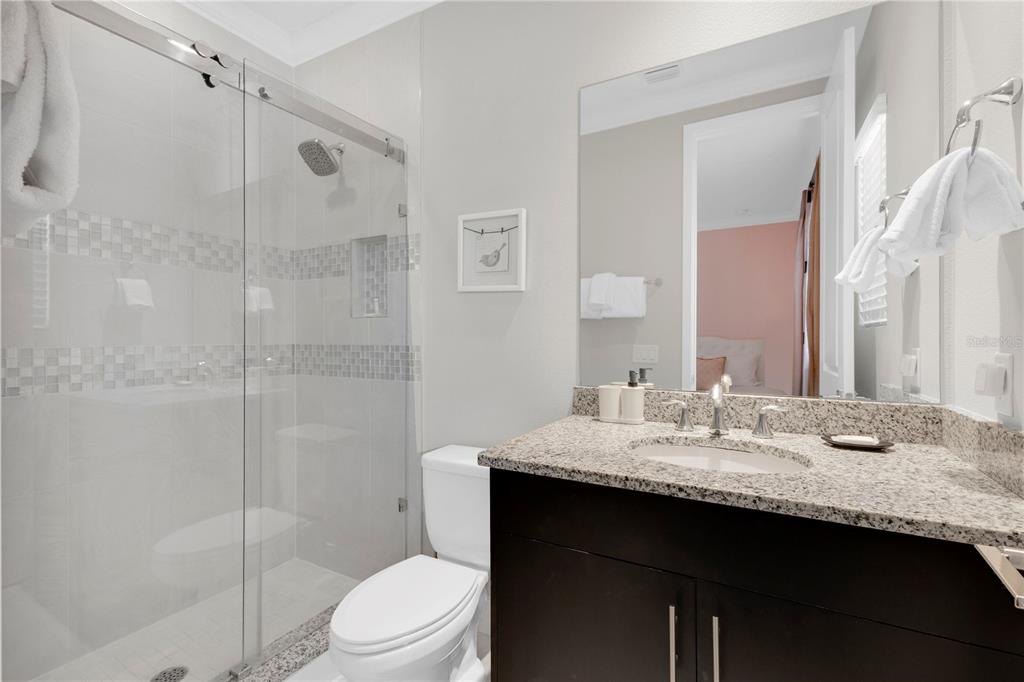 7580 Excitement Drive Reunion, FL 34747 - Photo 21 of 47 a bathroom with a granite countertop sink toilet a mirror and shower
