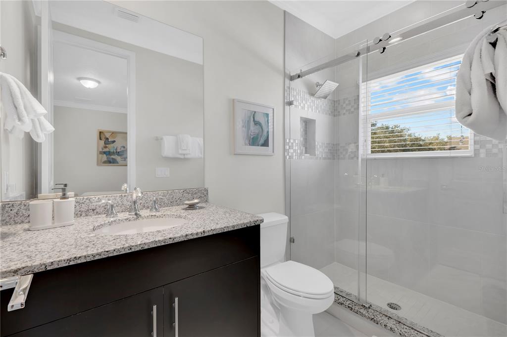 7580 Excitement Drive Reunion, FL 34747 - Photo 25 of 47 a bathroom with a granite countertop sink toilet and shower