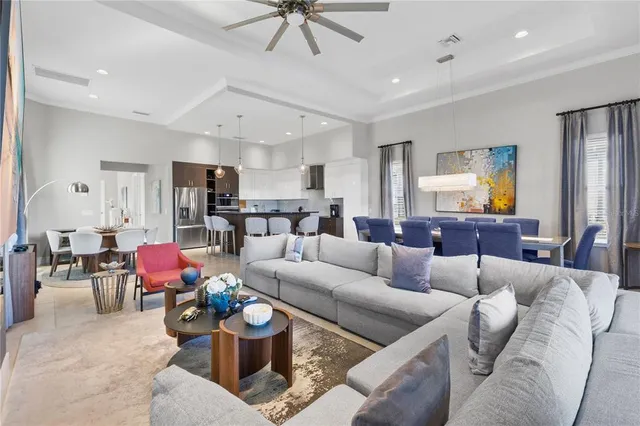 a living room with furniture kitchen view and a chandelier