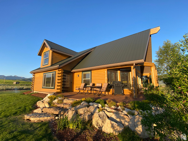 79 Auburn Forest Road Auburn, WY 83111 - Photo 8 of 76 View of front of house featuring a metal roof, a patio, log siding, and a mountain view