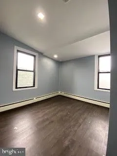 an empty room with wooden floor and staircase