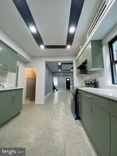 a large kitchen with stainless steel appliances granite countertop a sink and a refrigerator