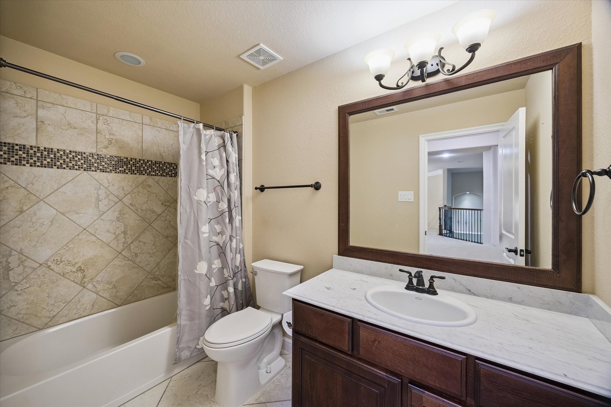 35 North Fremont Ridge Loop Spring, TX 77389 - Photo 28 of 37 A well-appointed secondary bathroom conveniently located off the upstairs landing. Featuring a spacious vanity with marble-look countertops, elegant framed mirror, and a tub/shower combination accented with decorative tile work, this bathroom comfortably serves family members and guests alike.