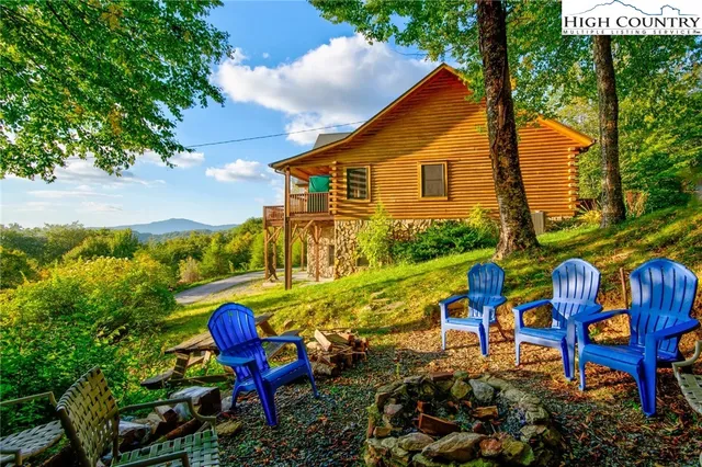 a view of a small barn with a red door and wooden fence