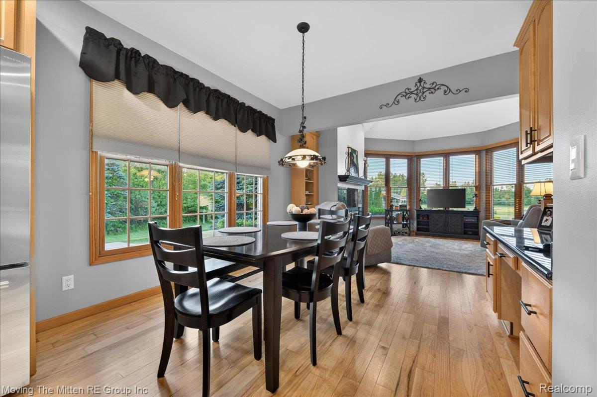 39750 Willow Road New Boston, MI 48164 - Photo 10 of 68 Dining area featuring wood-finish flooring, a pendant light fixture, and windows with wood trim