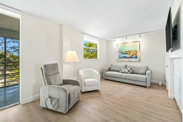 a living room with furniture and a painting on the wall