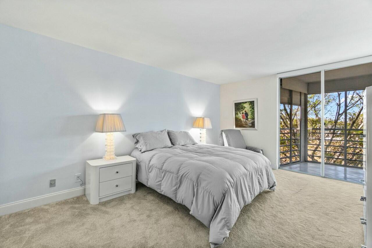 6461 Northwest 2nd Avenue, Unit 411 Boca Raton, FL 33487 - Photo 13 of 34 a bedroom with a bed and a large window