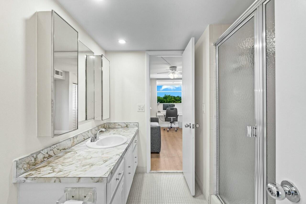 6461 Northwest 2nd Avenue, Unit 411 Boca Raton, FL 33487 - Photo 16 of 34 a bathroom with a granite countertop sink mirror and shower