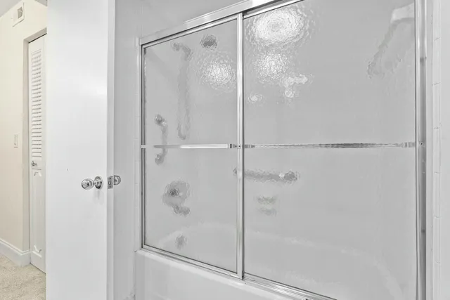 a bathroom with a glass shower door