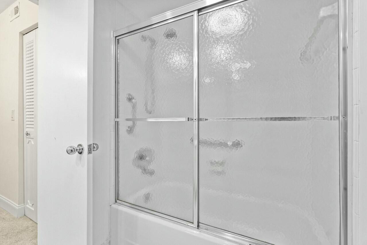 6461 Northwest 2nd Avenue, Unit 411 Boca Raton, FL 33487 - Photo 17 of 34 a bathroom with a glass shower door
