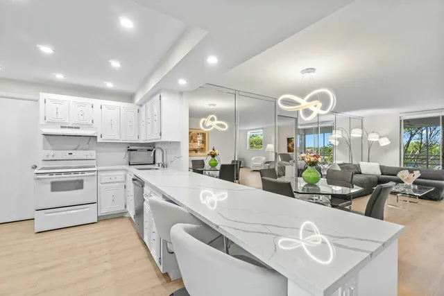 a large kitchen with kitchen island granite countertop a large counter top appliances and cabinets