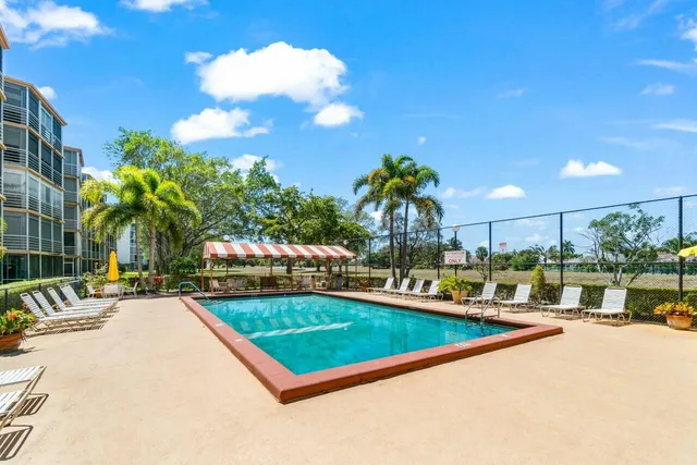 a view of a swimming pool with a patio and plants