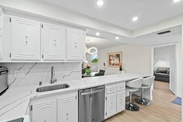 a kitchen with white cabinets and sink