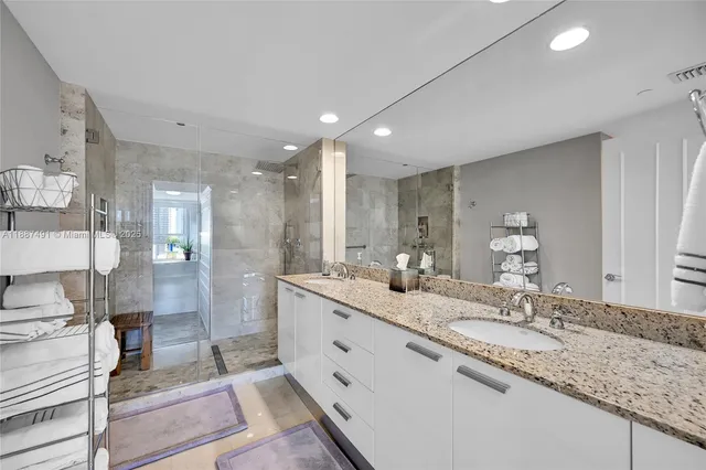 a bathroom with double vanity and a mirror