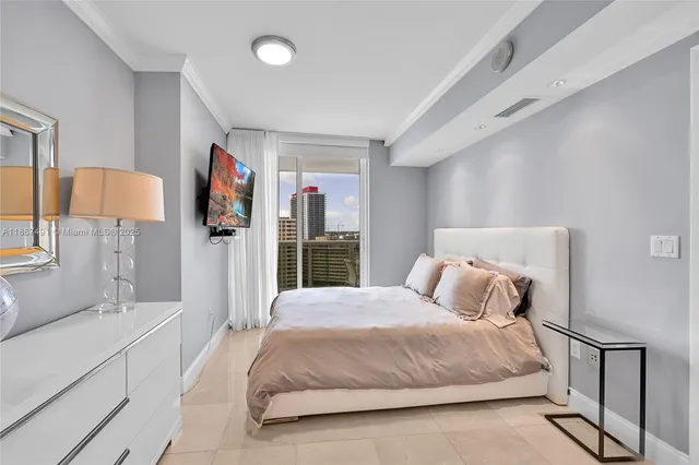 a bedroom with a large bed and a flat tv screen on dresser