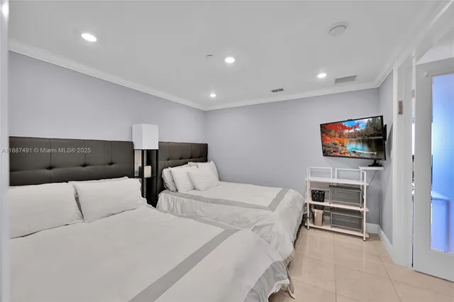 a hotel room with two bed and a flat screen tv