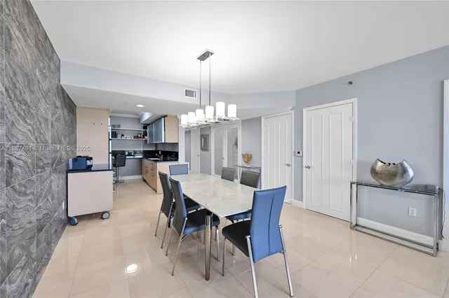 a view of a dining room and livingroom with furniture wooden floor a chandelier