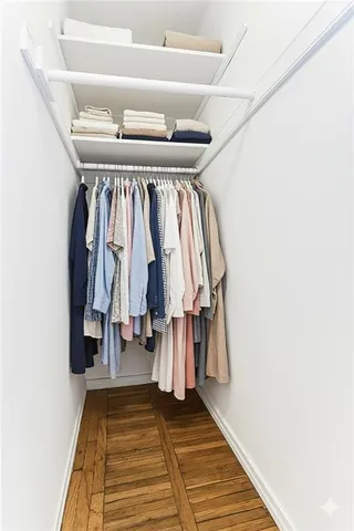 a view of walk in closet with clothes and shoes