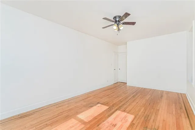a view of a room with wooden floor and a ceiling fan