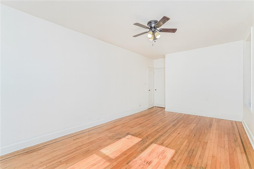 9437 Shore Road, Unit B9 Brooklyn, NY 11209 - Photo 20 of 22 a view of a room with wooden floor and a ceiling fan