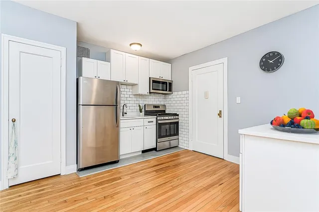 a kitchen with a refrigerator and a stove top oven