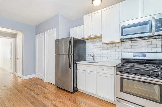 a kitchen with stainless steel appliances a stove microwave and refrigerator