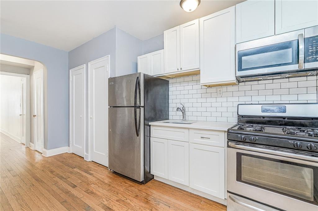 9437 Shore Road, Unit B9 Brooklyn, NY 11209 - Photo 7 of 22 a kitchen with stainless steel appliances a stove microwave and refrigerator
