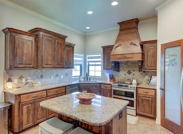 a kitchen with stainless steel appliances granite countertop a sink a stove and a wooden cabinets