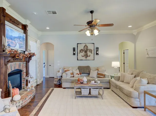 a living room with furniture a fireplace and a chandelier