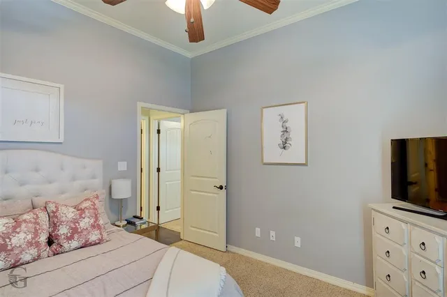 a bedroom with a bed and a flat tv screen on the dresser