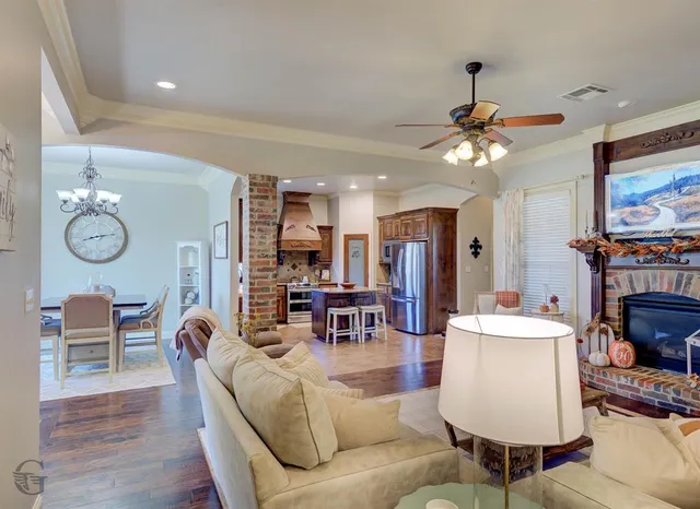 a living room with furniture a flat screen tv and kitchen view