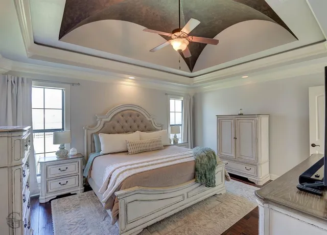 a bedroom with a large bed and a chandelier