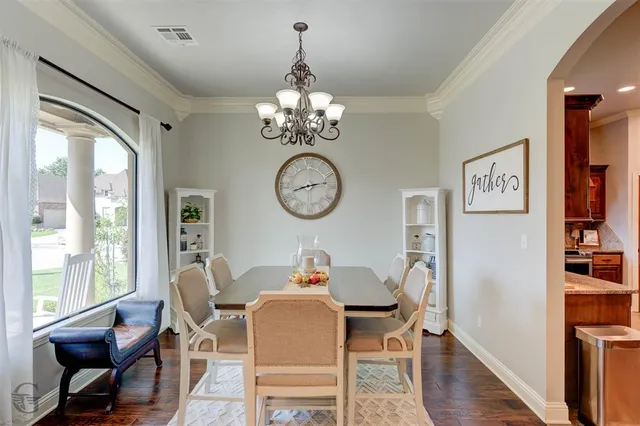 a view of a dining room with furniture a chandelier and wooden floor