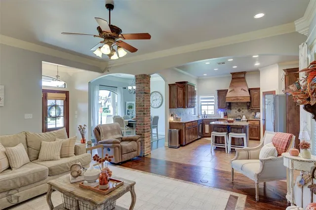 a living room with furniture a chandelier and a view of kitchen