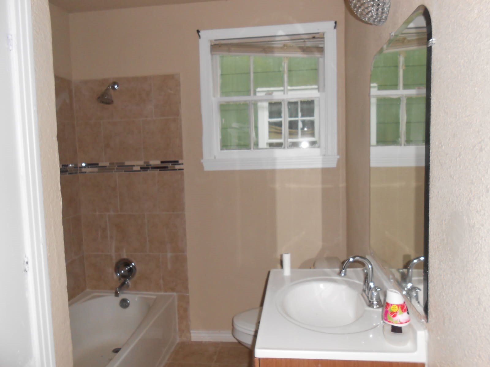 1050 Boyd Street Beaumont, TX 77705 - Photo 9 of 9 a bathroom with a tub a sink and a window