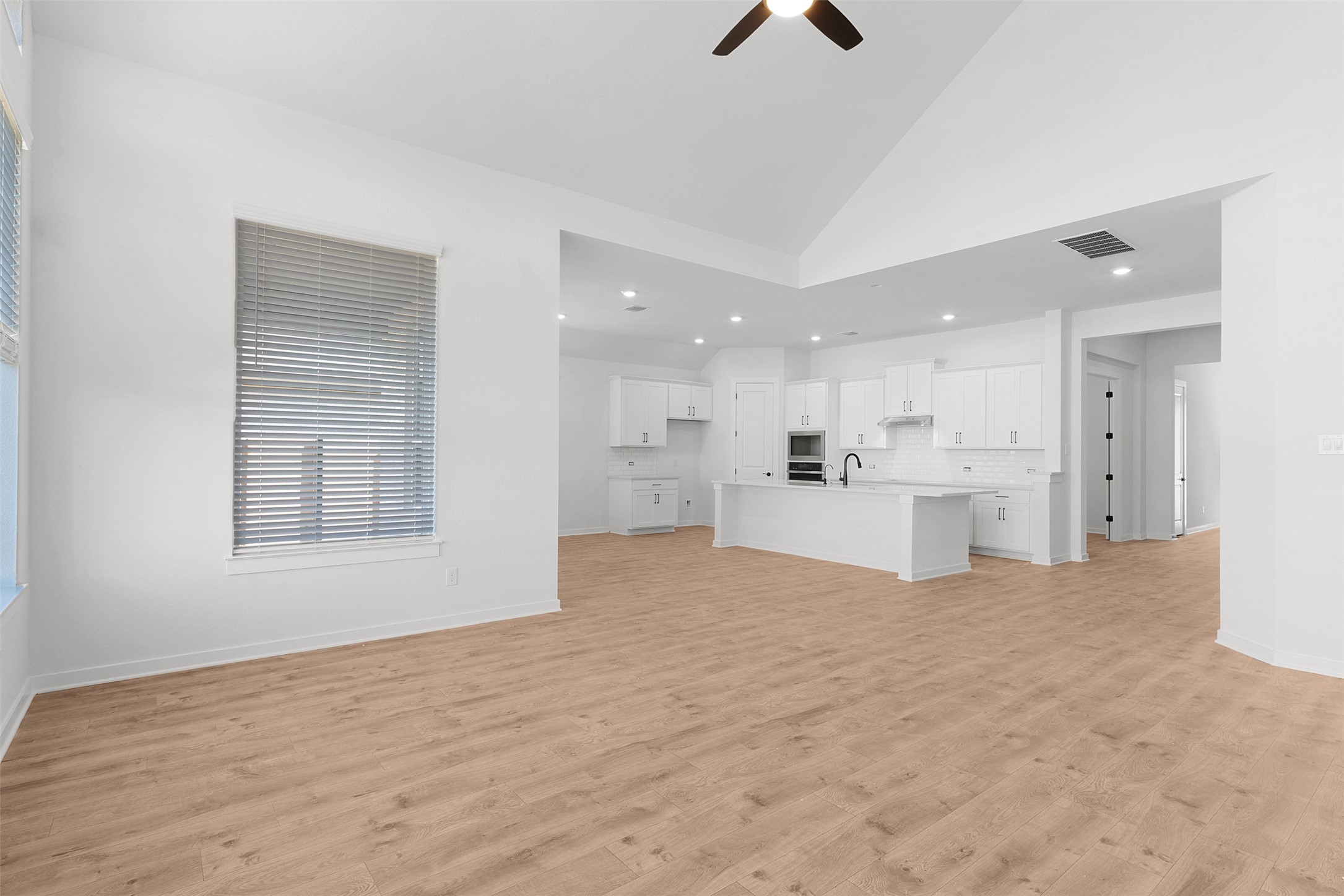 328 Ridgewell Loop Georgetown, TX 78633 - Photo 16 of 28 Unfurnished living room featuring high vaulted ceiling, light wood-type flooring, a ceiling fan, and healthy amount of natural light